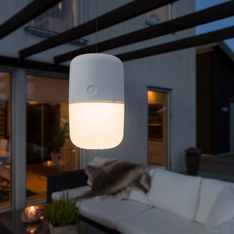 Solar LED Lamp Assisi om op te hangen of neer te zetten Wit hangt 's nachts in een stijlvolle buitenruimte.