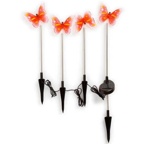Assisi Solar LED Vlinder Set 4-delig met vier kleurrijke vlinders op solarstokken in een tuin.