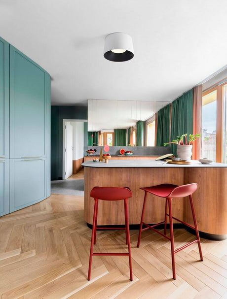 Plafonnier Atil LED Ø 50 cm 3000K dans une salle à manger moderne avec tabourets de bar rouges.