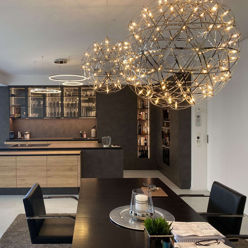 Modernes Kücheninterieur mit stilvollen Pendelleuchten und Essbereich in neutralen Farben.