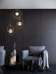 Atos LED Pendelleuchte Ø 40cm 3-flammig Gold 3000K in modernem Wohnambiente mit gemütlichem Sessel.