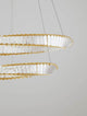 Aurelia LED Pendelleuchte 3500K Gold mit geometrischen Ringen und facettierten Glasstäben.
