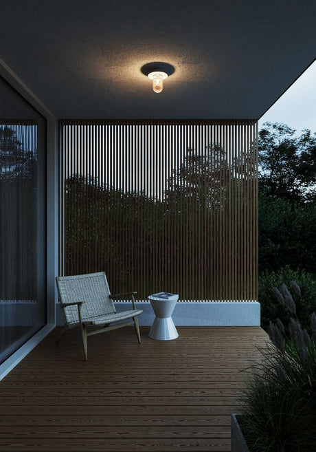 Plafonnier d’extérieur Januka IP54 sur une terrasse moderne avec sol en bois et aménagement minimaliste.