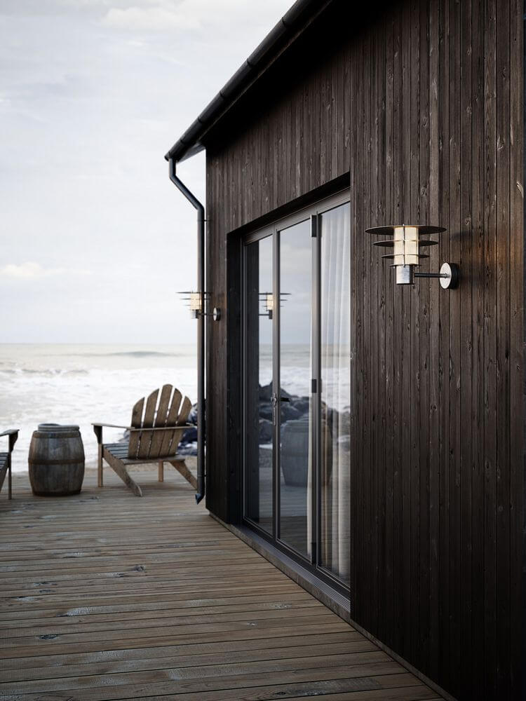 Außenwandlampe Bastia 35 IP54 an einer Holzfassade mit Meerblick