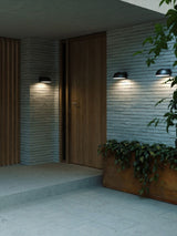 Elegante Außenwandlampe Clarso IP44 neben der Haustür mit modernem Design und sanftem Licht.