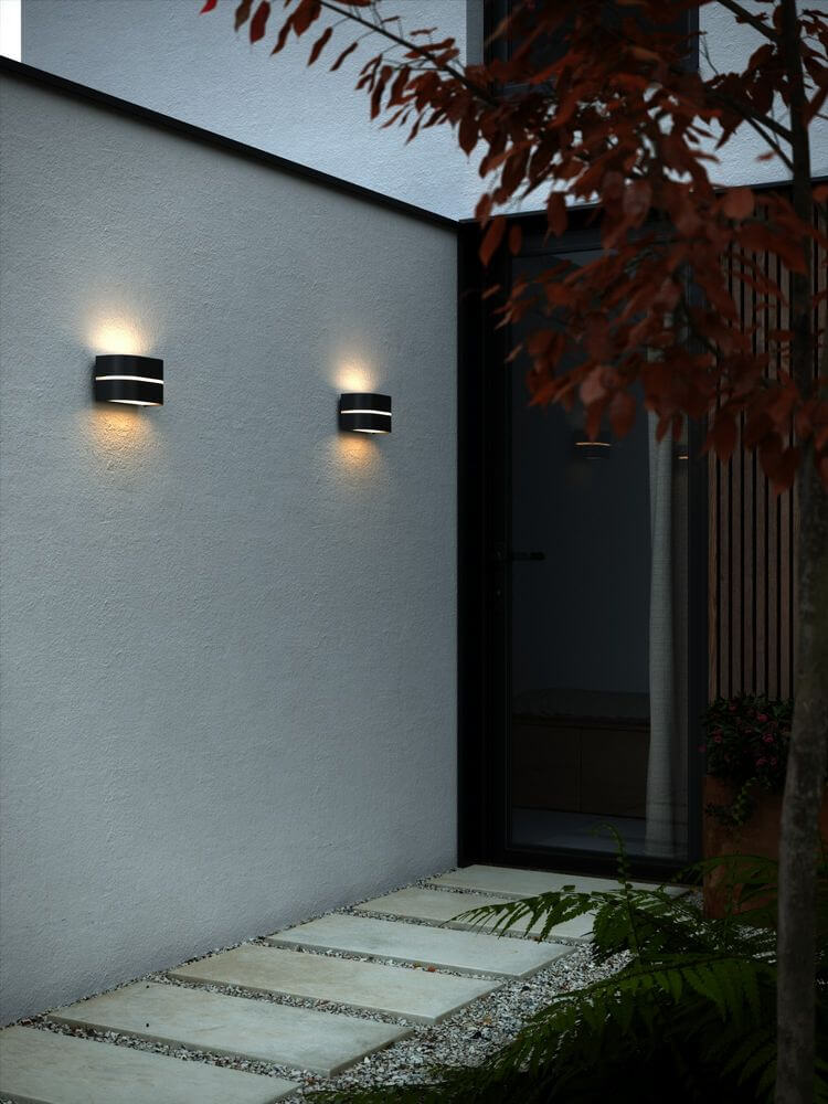 Außenwandlampe Sibelis IP44 an einer Hauswand mit sanftem Licht, ideal für atmosphärische Außenbereiche.