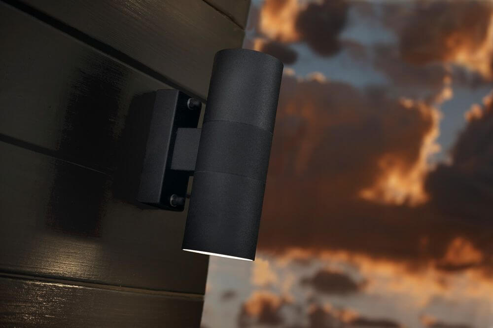 Außenwandlampe Tin Double IP54 an einer Wand montiert, stilvolles Design mit zwei Lichtquellen.