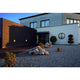 BULAN GRID Wandleuchte rund anthrazit E27 max. 2x25W PC Cover an moderner Fassade mit Steinen und Pflanzen.