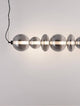 Bally LED Pendelleuchte 7-flammig in eleganter, zeitloser Ästhetik mit matt schwarzem Aluminium und rauchgrauem Glas.