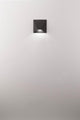 Bazz LED Wandleuchte 3000K an weißer Wand, modernes Design aus schwarzem Aluminium.