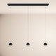s.luce Beam LED Esstisch-Pendelleuchte Balken 120cm mit drei hängenden, schwarzen Lampen.