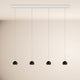 s.luce Beam LED Esstisch-Pendelleuchte Balken 120cm mit vier schwarzen Pendelleuchten an einer weißen Decke.