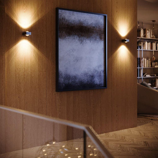 s.luce Beam X modern vägglampa Up & Down kvadratisk på väggen med konstverk i modern bostad.