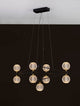 Belinda LED Pendelleuchte 9-flammig mit geometrischem Design und 9 dekorativen Glaskugeln über schwarzem Hintergrund.