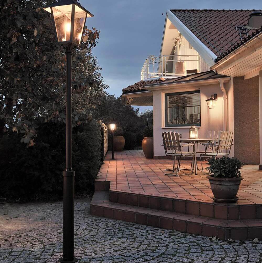 Benu Mastleuchte 254cm Schwarz, rauchfarbenes Acrylglas auf einem elegant beleuchteten Patio.
