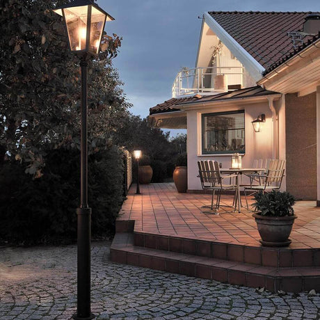 Benu mast light 254 cm black, smoked acrylic glass on an elegantly lit patio.