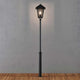 Benu Mastleuchte 254cm Schwarz, rauchfarbenes Acrylglas auf Holzoberfläche beleuchtet.
