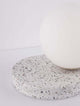 Beson Tischleuchte H 18cm Grau, Weiß auf einem terrazzo Untergrund mit Kugel aus weißem Material.