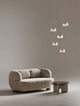 Bion LED Pendelleuchte 5-flammig Ø 50cm 3000K Gold über modernem Sofa und Tisch.