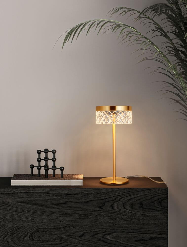 Bion LED Tischleuchte Ø 14,8cm 3000K Gold auf einem Sideboard im modernen Wohnraum.