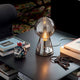 Birillo mundgeblasene Glas Tischleuchte 30cm Rauch auf einem Tisch mit verschiedenen Büchern und einer dekorativen Schale.