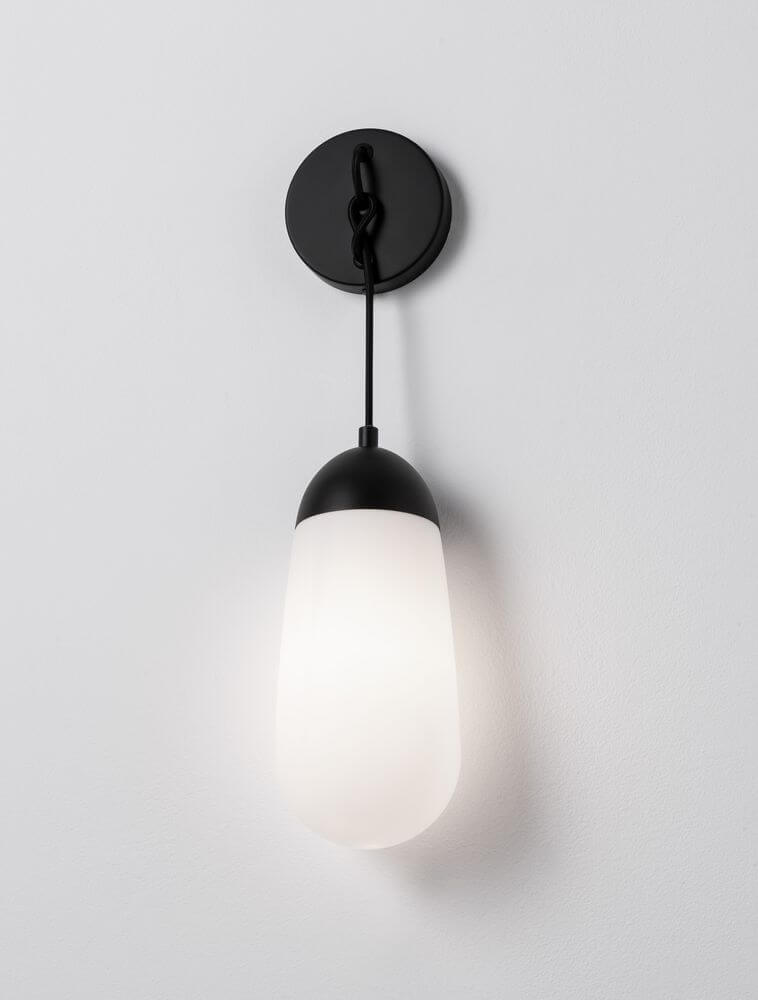 Blaky Wandleuchte Schwarz, Weiß mit mattem Opalglas und eleganten Linien an einer Wand montiert.