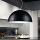 s.luce Blister Pendelleuchte in Schwarz mit silberner Innenfläche, ideal für Esstische und hohe Räume.