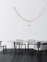 Brillante 12-flammige Pendelleuchte von Nova Luce über einem modernen Esstisch, elegantes Lichtdesign in Aluminium und Glas.