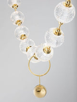Brillante Pendelleuchte mit klaren Kristallkugeln und goldenen Akzenten, ideal für moderne Wohnräume.