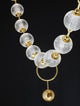 Brillante LED Pendelleuchte 12-flammig 3200K mit eleganten Glas- und Goldakzenten auf schwarzem Hintergrund.