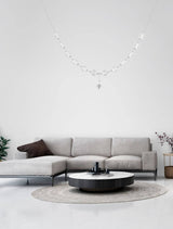 Brillante LED Pendelleuchte 12-flammig über modernem Sofa und Couchtisch in stilvollem Wohnraum.
