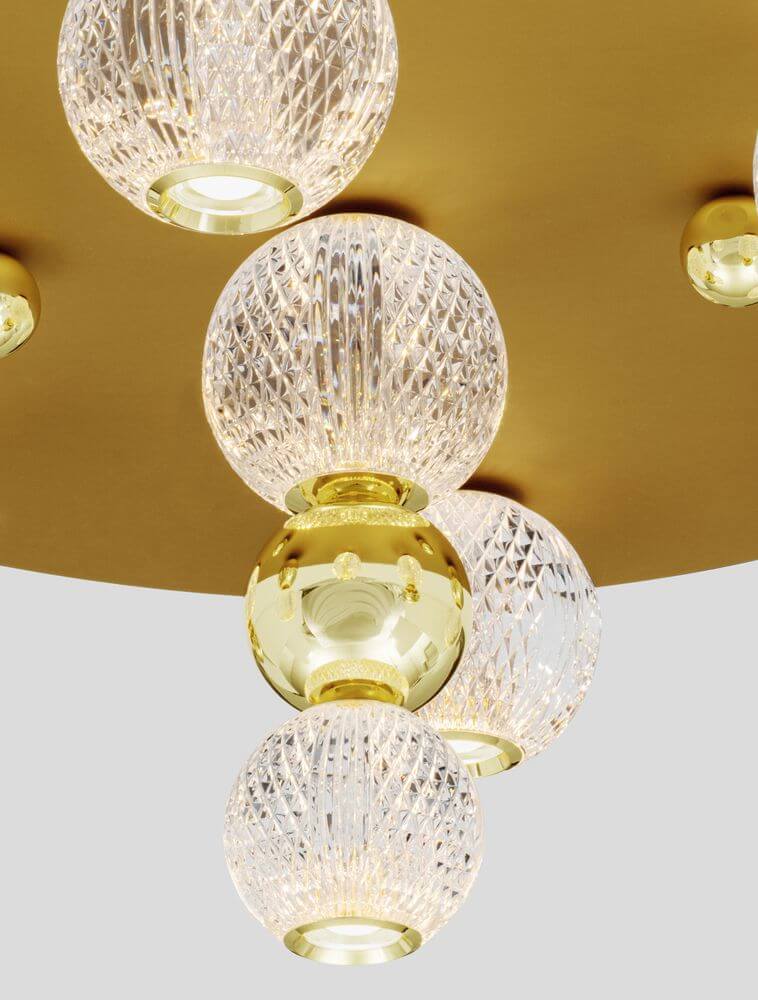 Brille LED Deckenleuchte 7-flammig Ø 66cm 3200K Gold mit kristallenen Lampenschirmen auf goldfarbenem Hintergrund.