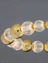 Brille LED Pendelleuchte mit goldenen Elementen und gläsernen, funkelnden Lampen.