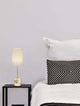 Brille LED Tischleuchte 2-flammig Ø 15,4cm 3200K Gold auf Nachttisch neben einem Bett.