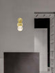Brille LED Wandleuchte 3200K Gold an einer modernen Wand in einem stilvollen Raum.