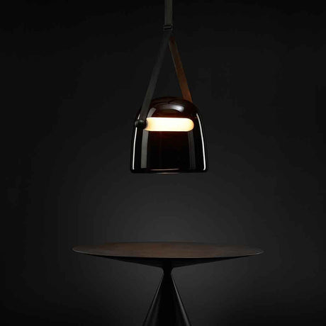 Brokis pendellampe Mona XL i elegant design, med dimbar LED-belysning, svevende over et bord.