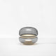 Brokis Tischlampe Macaron S mit grauem mundgeblasenem Glas und Onyxbasis, die ein sanftes Licht ausstrahlt.