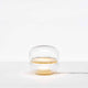 Brokis Tischlampe Macaron S mit transparentem Glas und Onyxbasis, sanftes Licht strahlt nach oben.