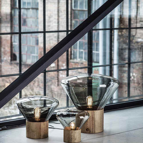 Brokis Tischlampe Muffins Mini Wood 06 in einem modernen Raum mit großen Fenstern.