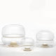 Brokis Tischleuchte Macaron L in transparentem Glas mit onyxfarbener Basis, elegant und modern.