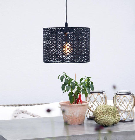 Suspension d’extérieur Maison IP44 Ø 36 cm noir sable au-dessus d’une table avec des plantes et des éléments décoratifs.