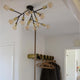 Taklampe Heroes med 12 lyskilder i svart i et moderne interiør med klare lyspærer.