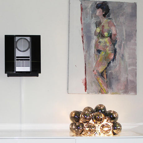 Large glass table lamp Ø 38cm smoke-coloured in a modern living environment with artwork in the background.