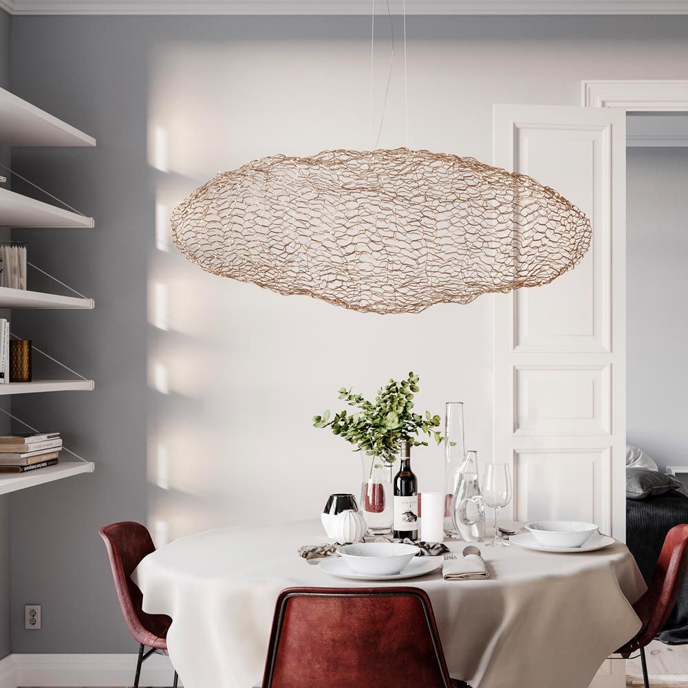 LED-hengelampe Hayden L 76 cm gullfarget over et elegant spisebord i moderne omgivelser.