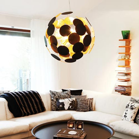 Lampadario Planet Ø 50cm Nero Sabbia, Color Oro nel soggiorno sopra un divano bianco.