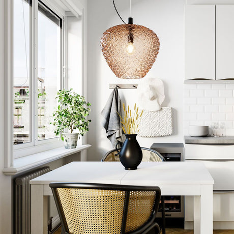 Suspension en verre structuré Mabeo Ø 29 cm ambré au-dessus d'une table blanche dans une cuisine moderne.