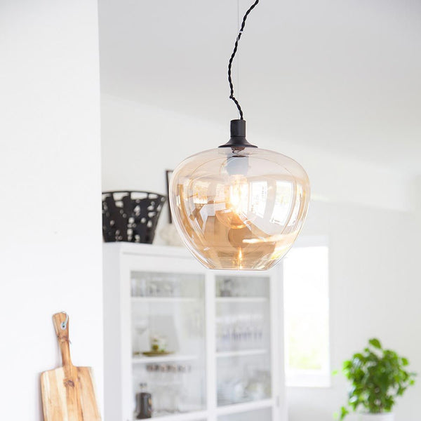 Suspension Bellissimo Ø 28 cm teintée fumée suspendue dans un espace de vie moderne.