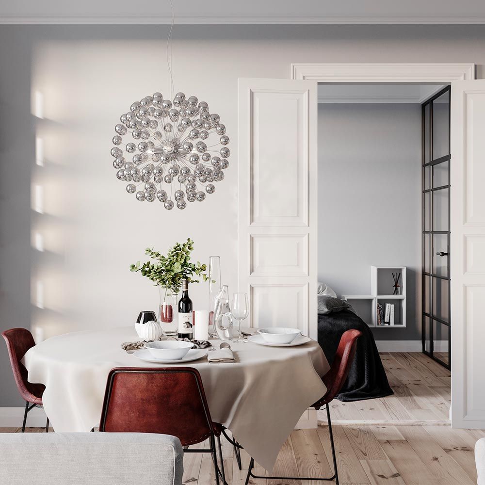 LED-hengelampe Carroll Ø 58 cm krom over et spisebord i et moderne interiør.