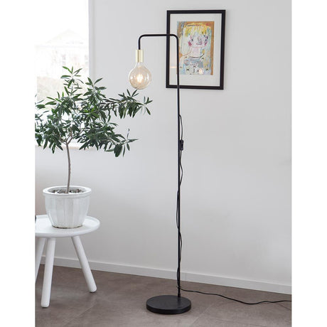 Fondi floor lamp 150 cm black with matte brass lamp holder in a modern living ambience.