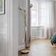 Stehleuchte 3Some 3-flammig Antikgold steht in modernem Wohnraum mit großen Fenstern und stilvollem Design.